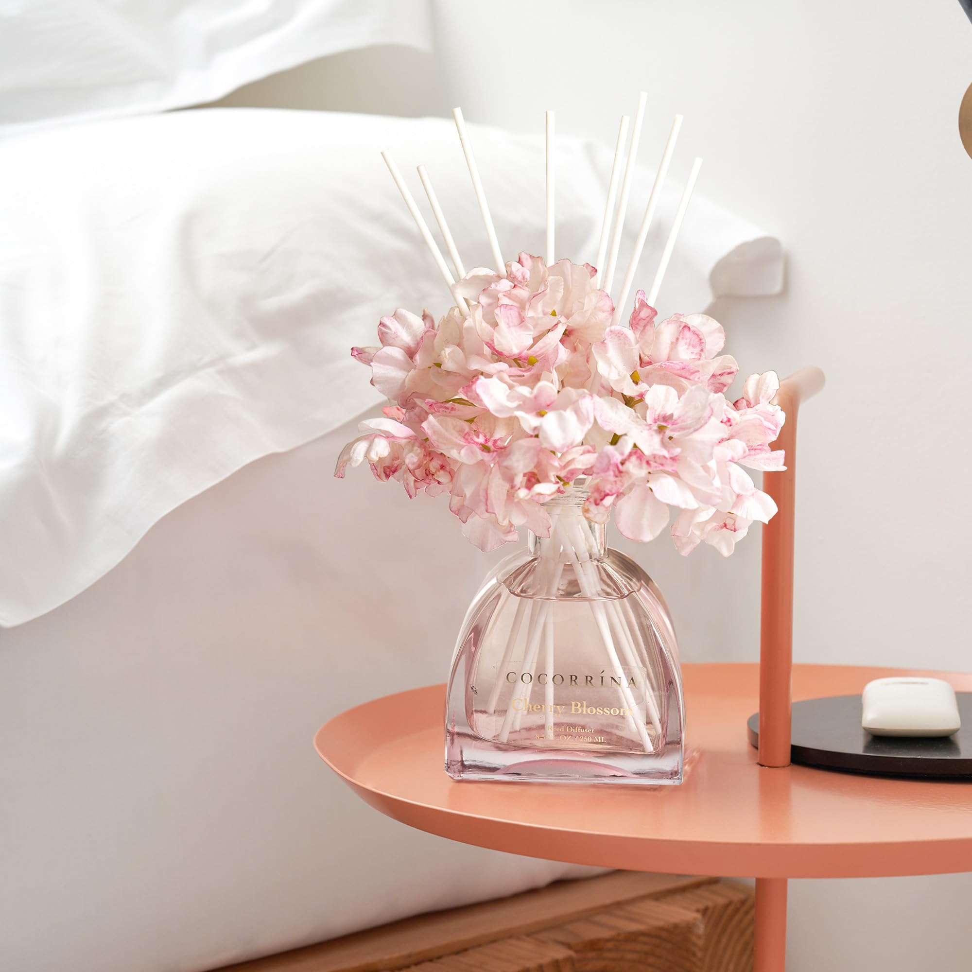 COCORRÍNA cherry blossom diffuser on a living room shelf for inviting ambiance.