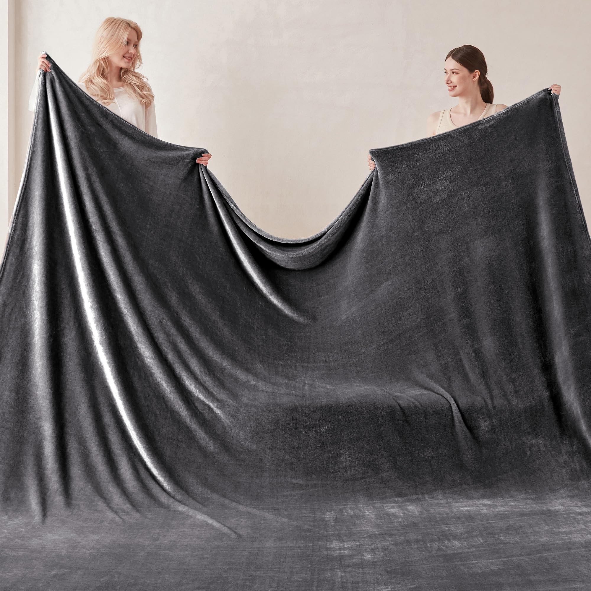 COOVA oversized king blanket draped on bed and sofa for cozy lounging.