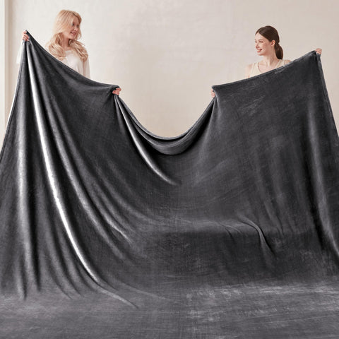 COOVA oversized king blanket draped on bed and sofa for cozy lounging.