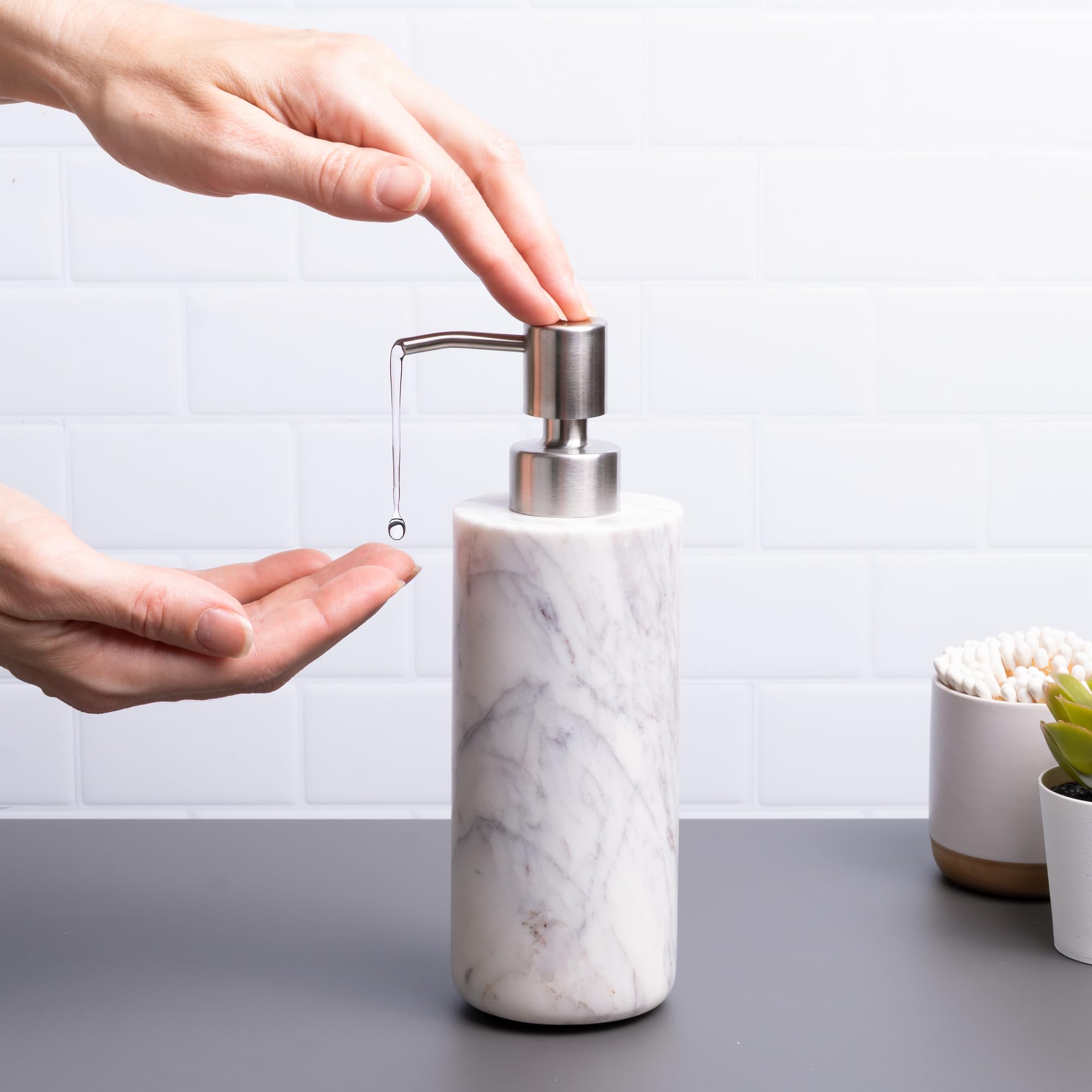 Cork & Mill marble dispenser close-up shows brushed stainless pump for durable use.