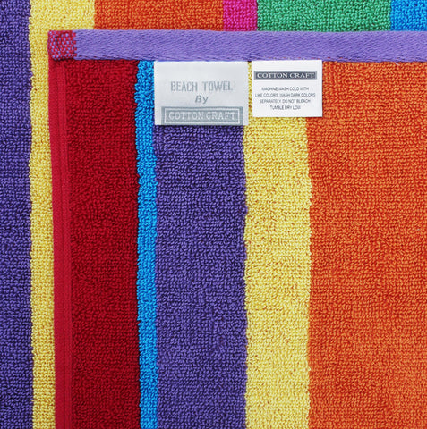 Cotton Craft oversized towel on sand demonstrates roomy coverage for lounging.