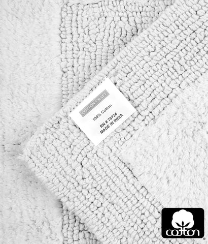Cotton Craft white bath mats in a bathroom, clean and timeless addition.