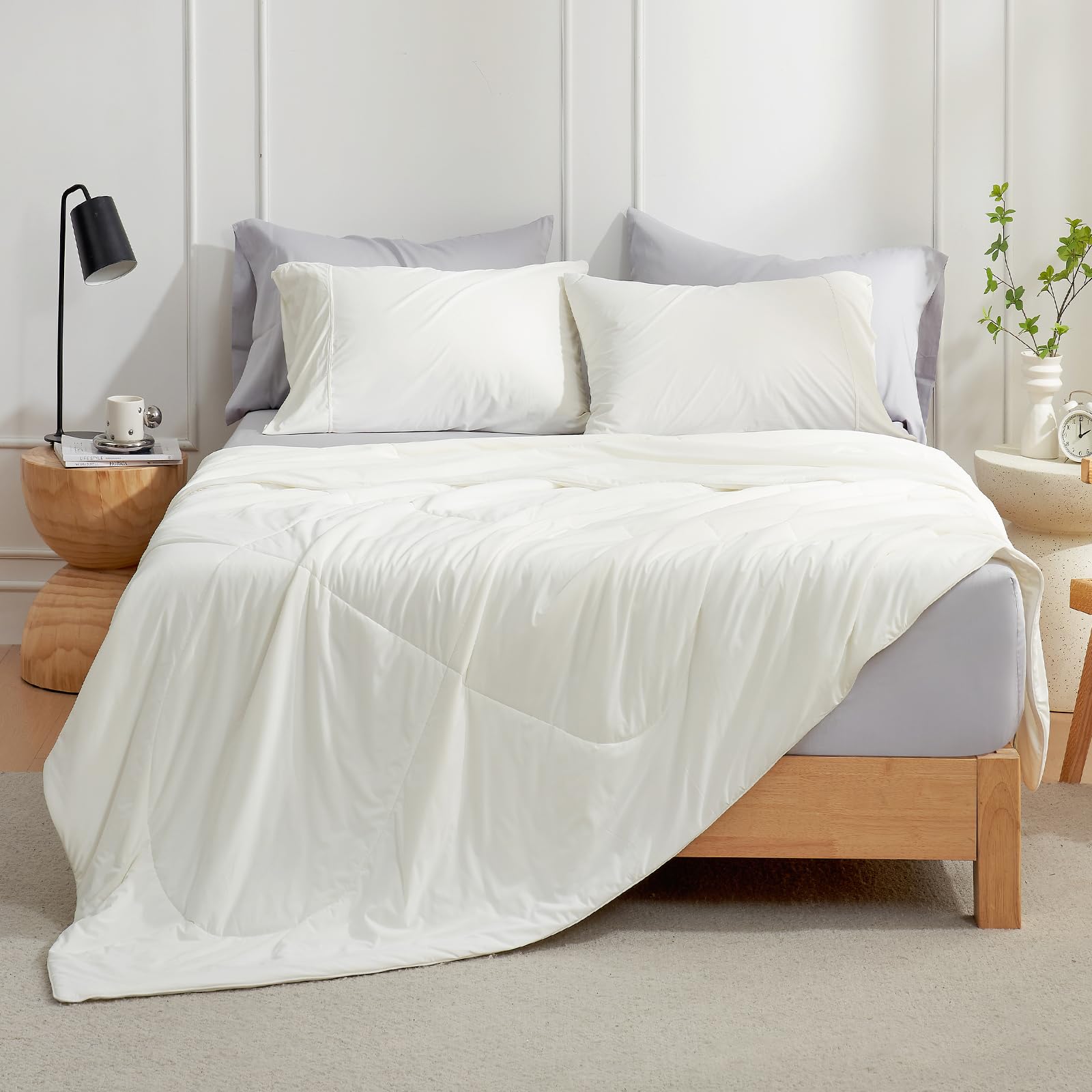 Cozy Bliss cooling comforter folded neatly on a cream queen bed