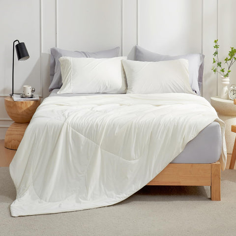 Cozy Bliss cooling comforter folded neatly on a cream queen bed