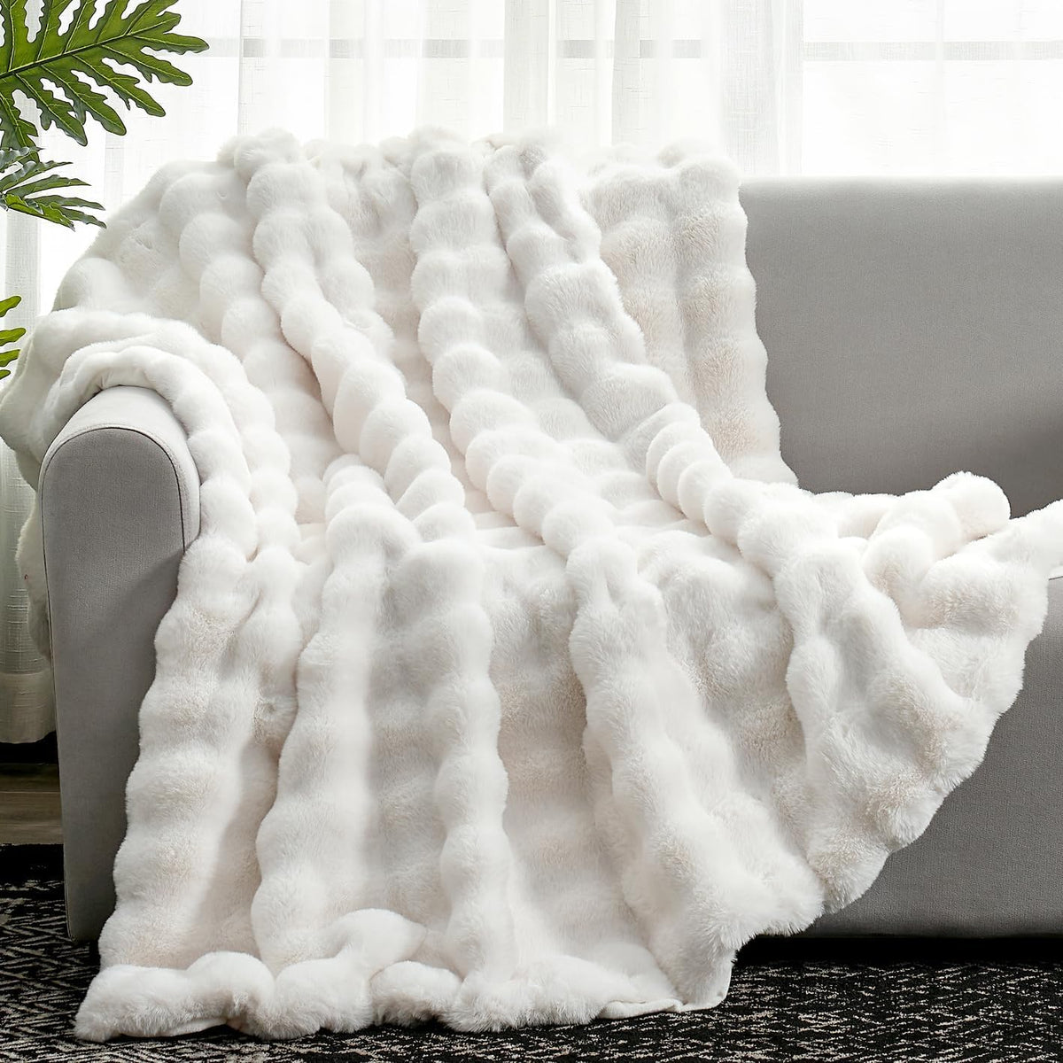 Cozy Bliss faux fur throw blanket on sofa with creamy texture.
