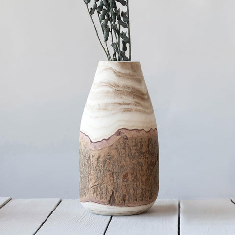 Creative Co-Op carved paulownia vase on a desk with botanicals