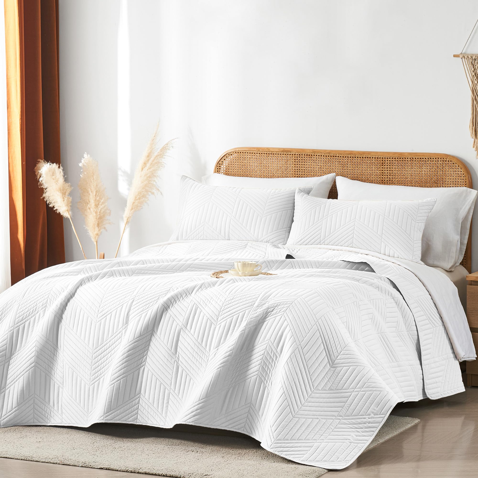 White reversible microfiber coverlet by Davulos offers lightweight softness for year-round use.