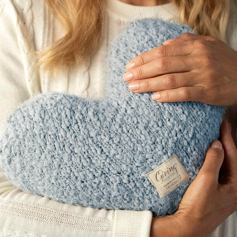 Artisan craftsmanship and soft fabric elevate tactile appeal of the weighted heart pillow.