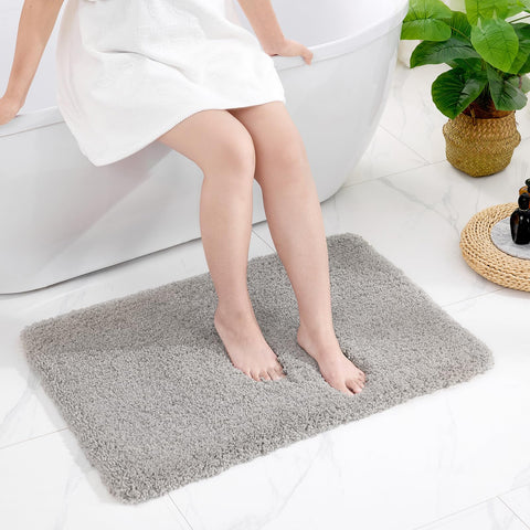 Disolla grey mat beside tub enhances comfort and safety.