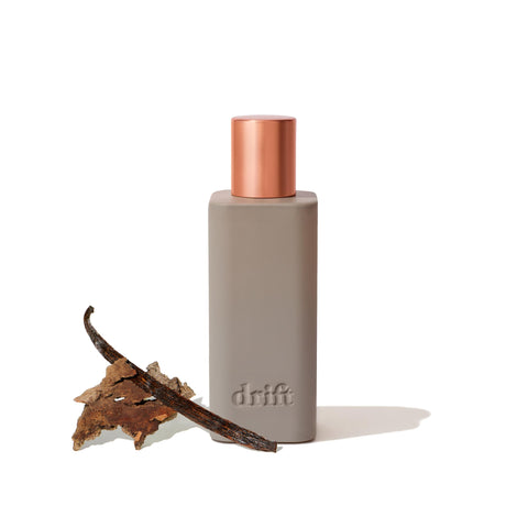 Drift Vanilla Woods room spray bottle emits warm vanilla and cedarwood for inviting spaces.