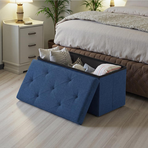 DUMOS blue bedside ottoman used as a compact storage seat.