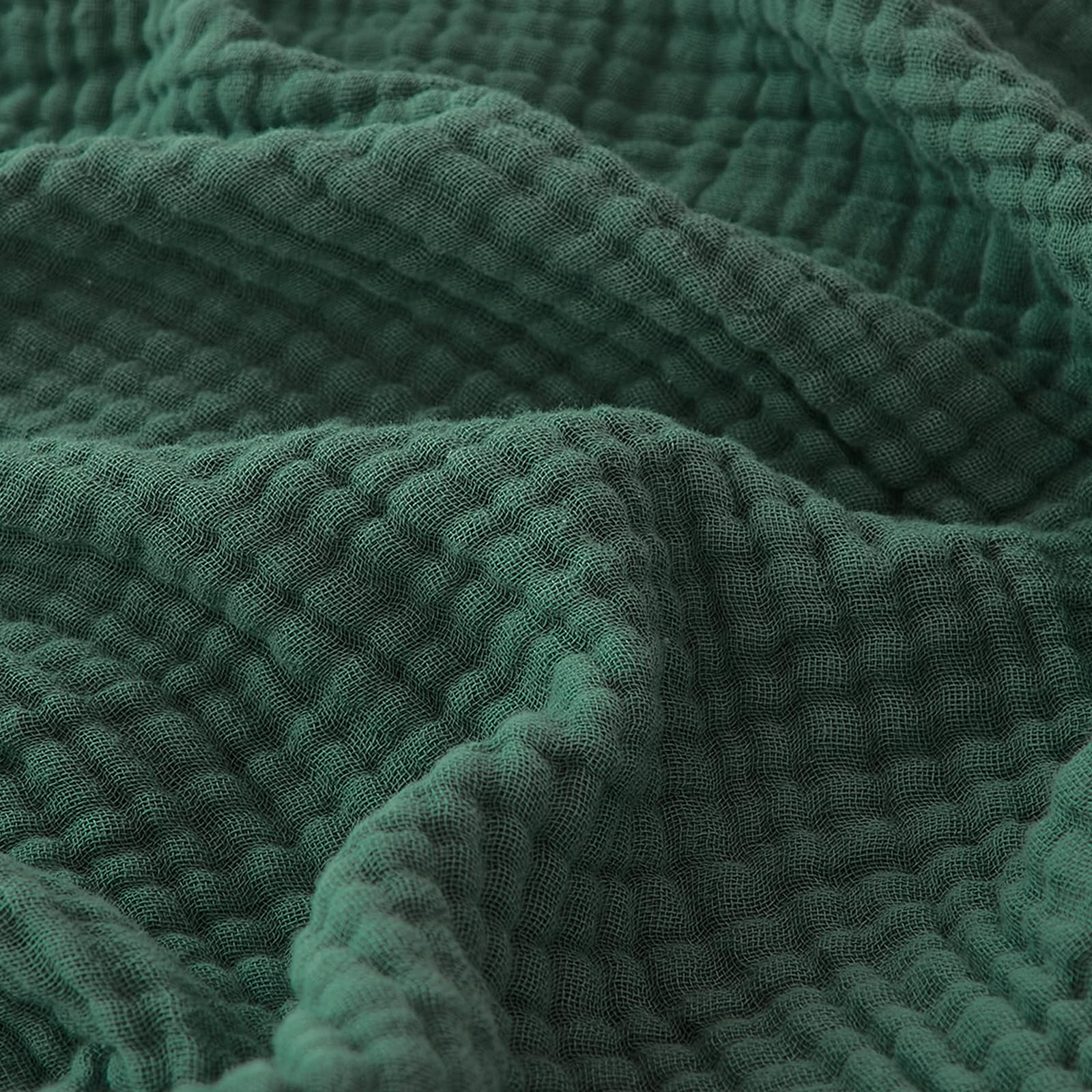 EMME forest green blanket on sofa, breathable comfort for lounging