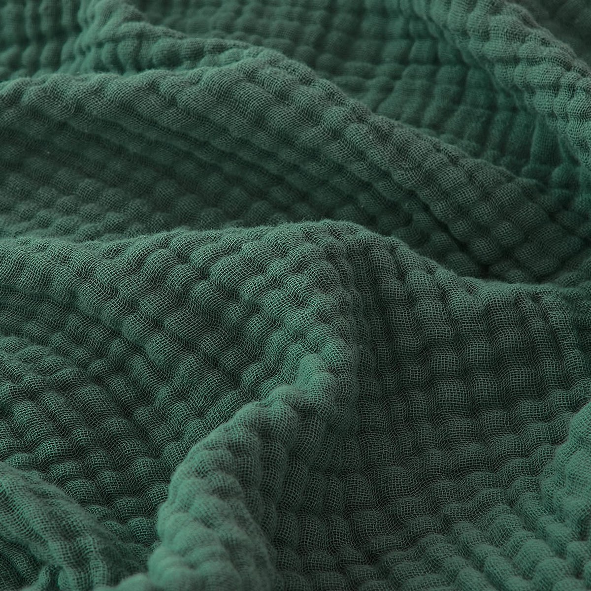 EMME forest green blanket on sofa, breathable comfort for lounging