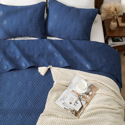EMME Quilts on-bed display shows all-season warmth with lightweight comfort.