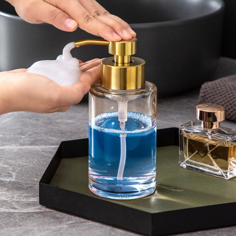 Enra Gold Foaming Soap Dispenser on bathroom counter with warm glass finish