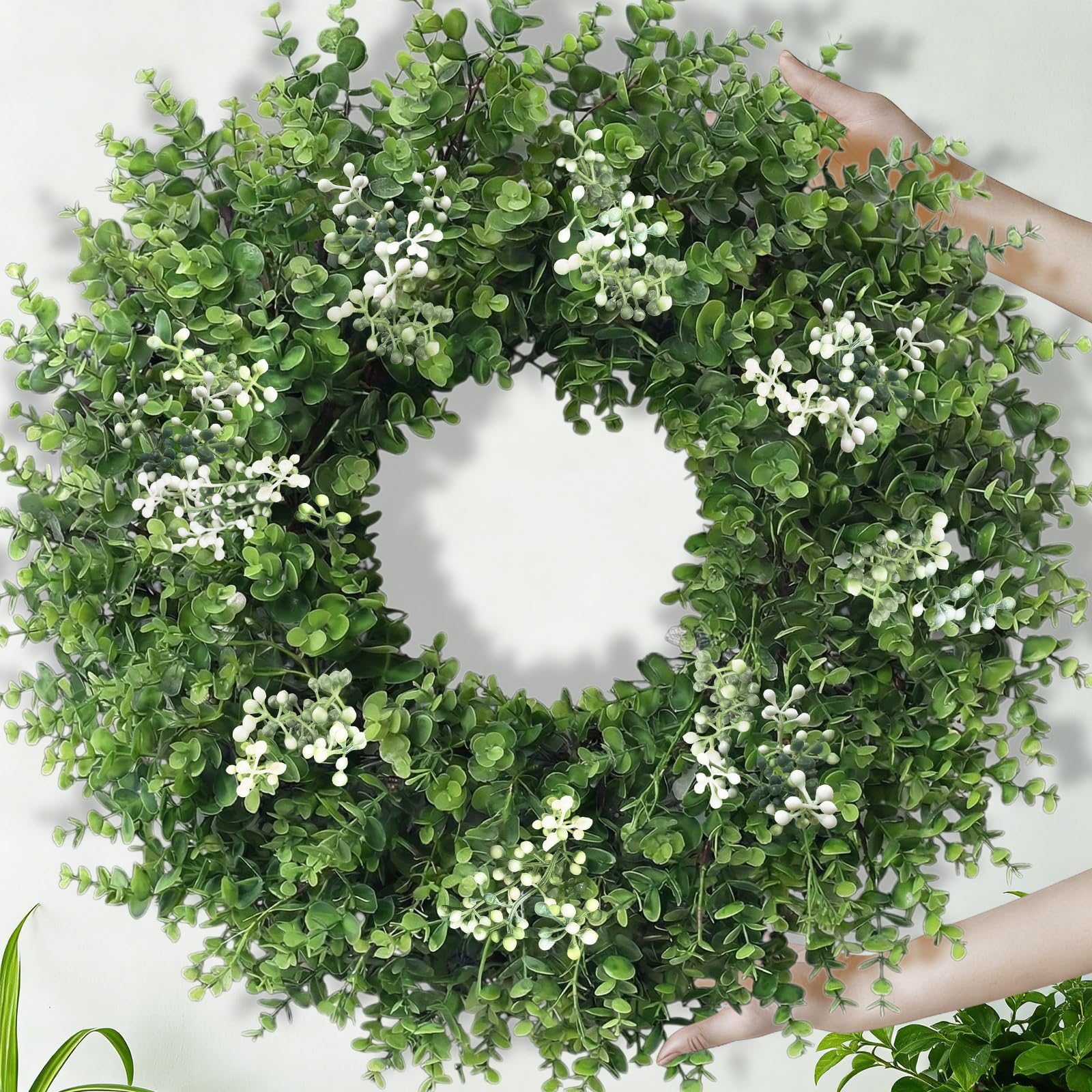 Eqanro boxwood wreath closeup shows lifelike leaves and small white blossoms