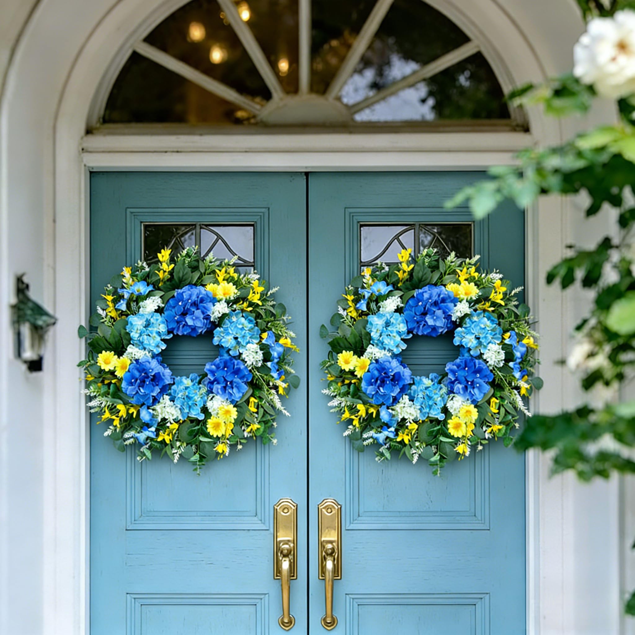 Eqanro outdoor wreath with blue hydrangeas and white daisies adds color to exteriors.