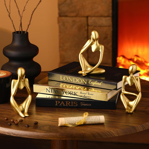 Feifeiya gold thinker statues paired with black hardcover books elevate desk or shelf decor.
