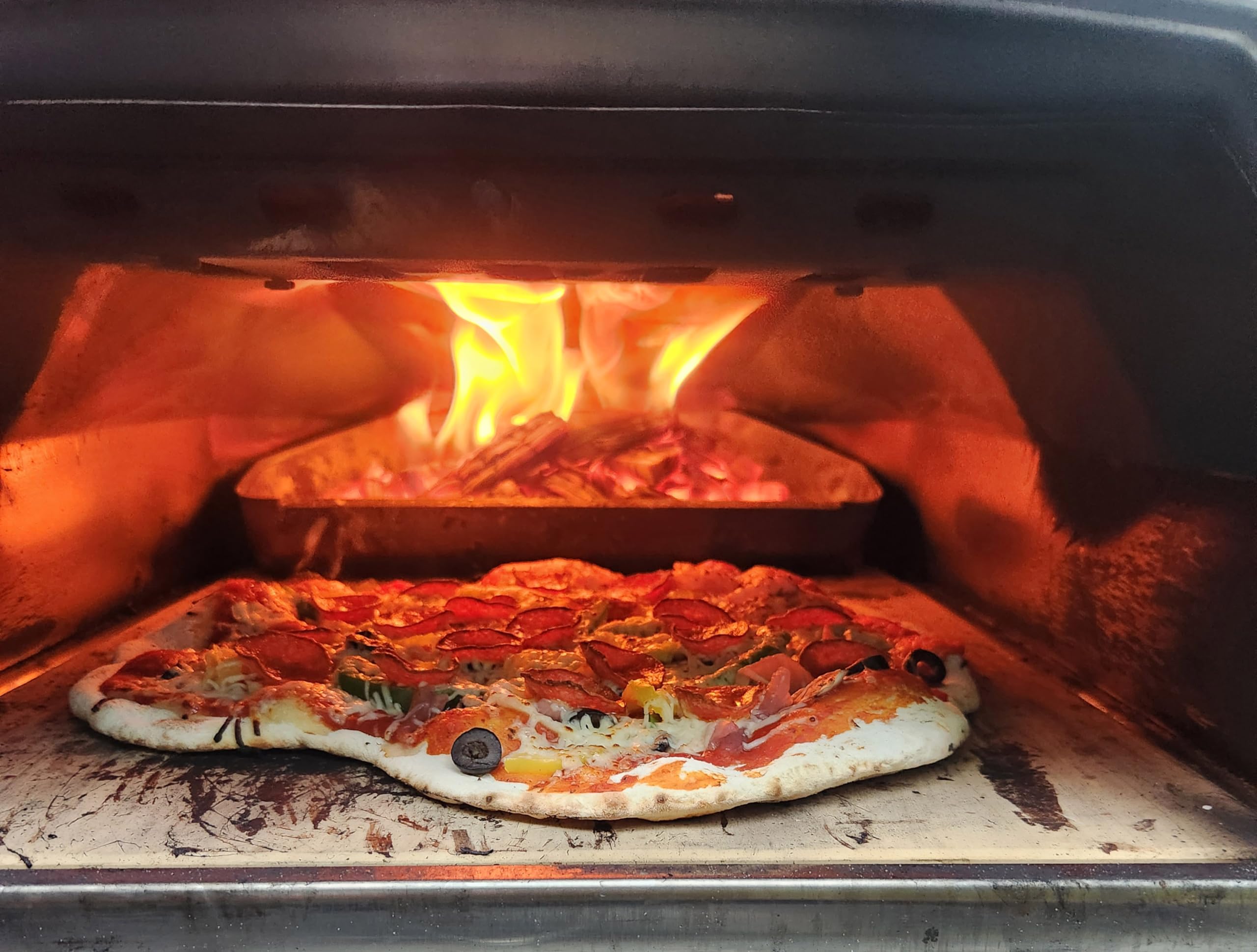 Portable wood-fired oven setup using FiveOaks cherry wood for outdoor cooking.