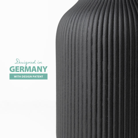 Flature black vase on windowsill complements stems and dried arrangements