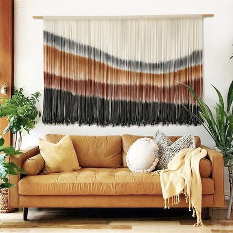 Flber macrame wall hanging with coffee tie-dye adds boho charm to living room decor.