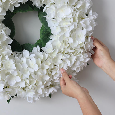 Wreath displayed on wooden door creates a farmhouse or modern entry focal point