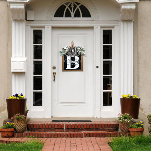 Generic eucalyptus garland and bow adorns front door for seasonal styling