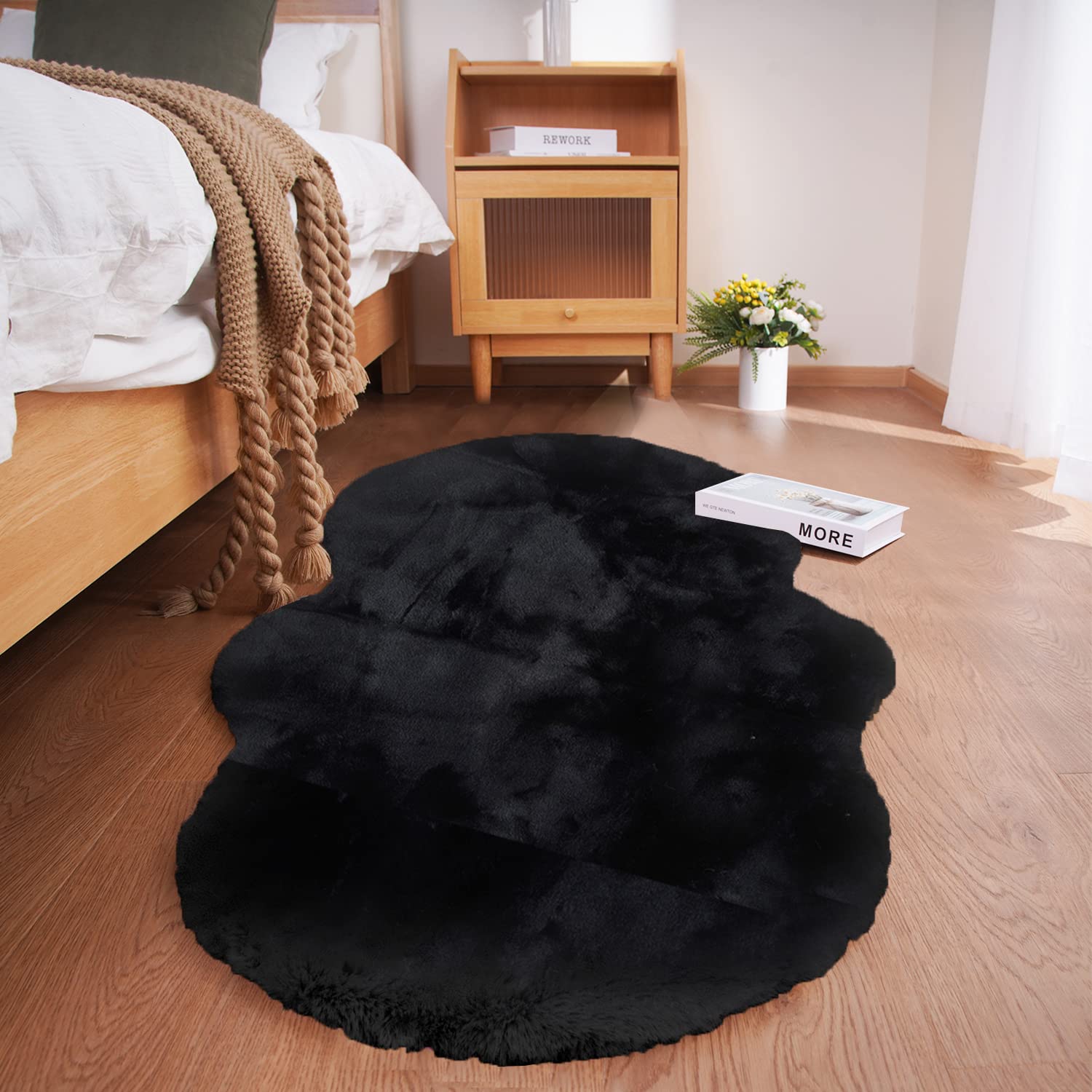 Ghouse soft faux sheepskin rug 2x4 black, side view, cozy surface for living spaces.
