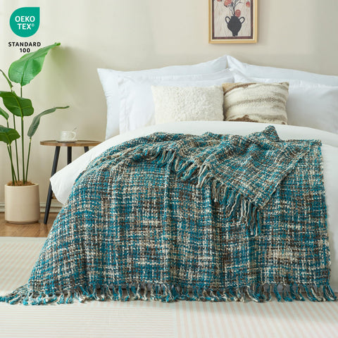GINAMUSE teal cable-knit throw with tassels enhances warm bed decor.