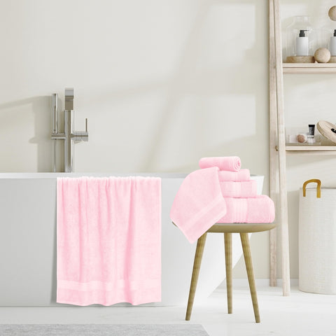 Towels draped in a modern pink bathroom with hotel-style quality.