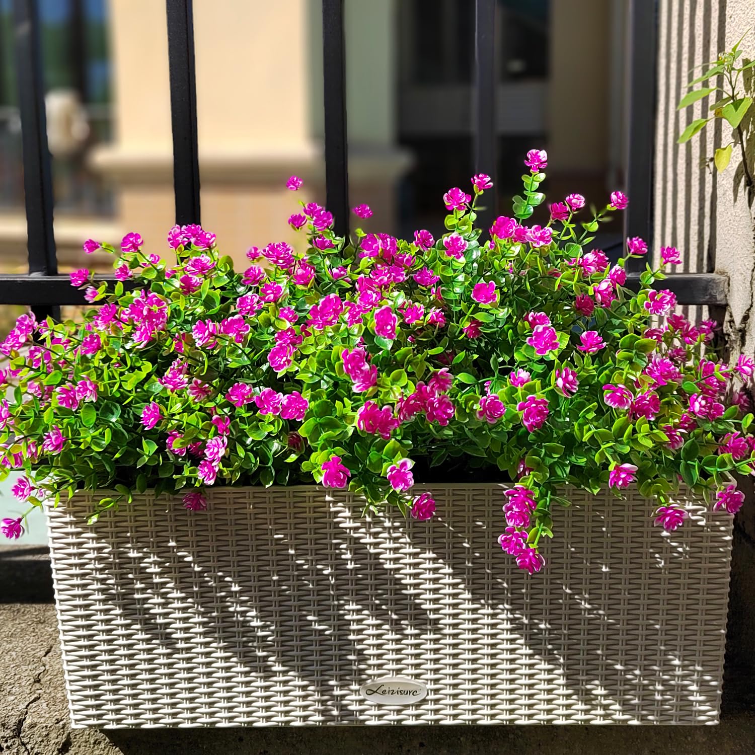 Grunyia weather-resistant artificial flowers adorn a hanging planter.