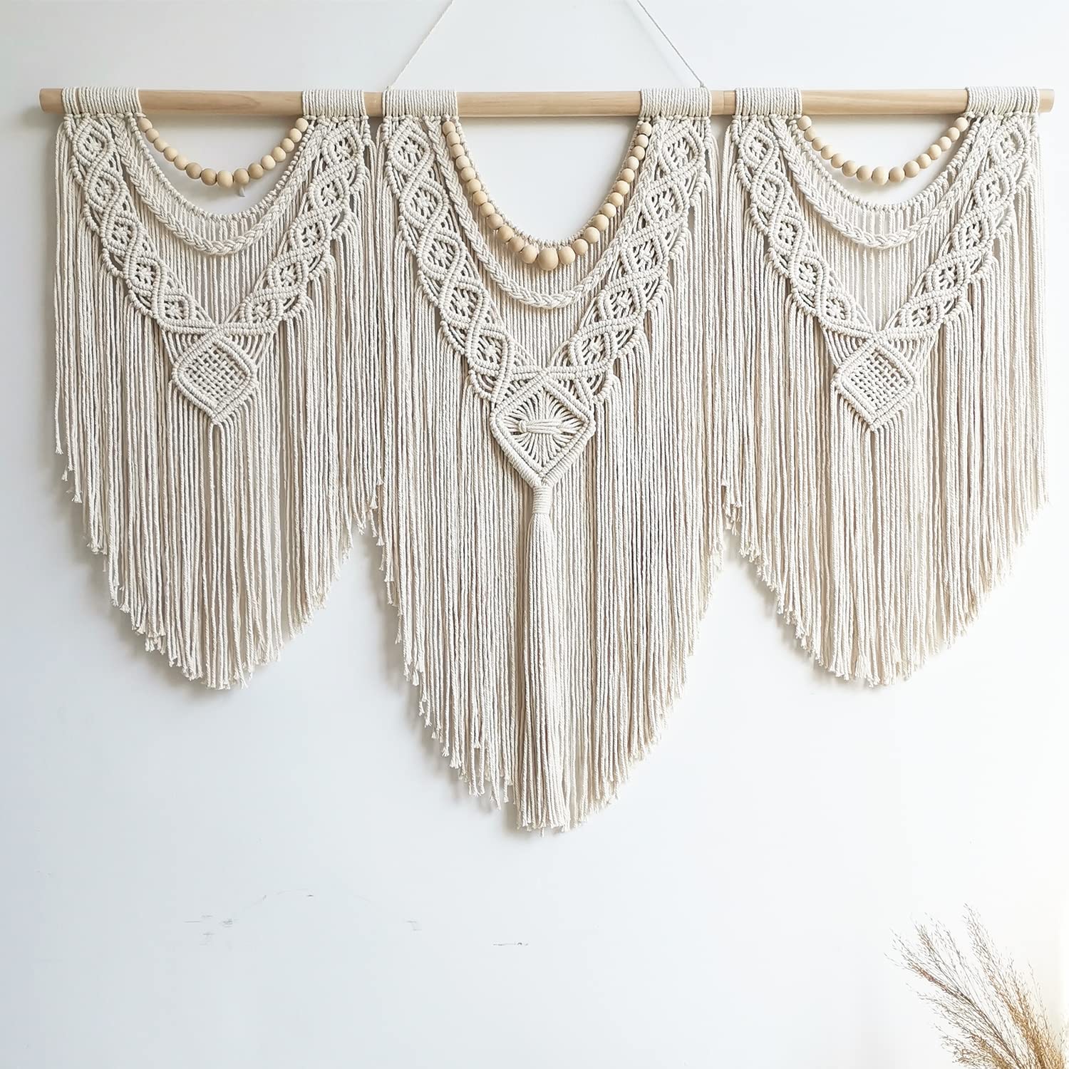 Guzhiou large macrame wall hanging with fringe adds texture to a bedroom.