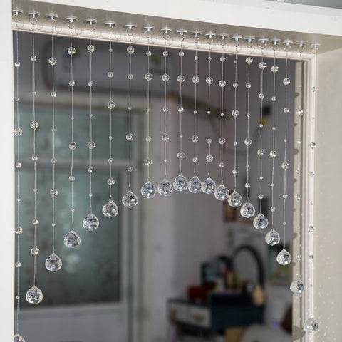 Hanbinsen crystal bead curtain arches over a doorway to diffuse light elegantly