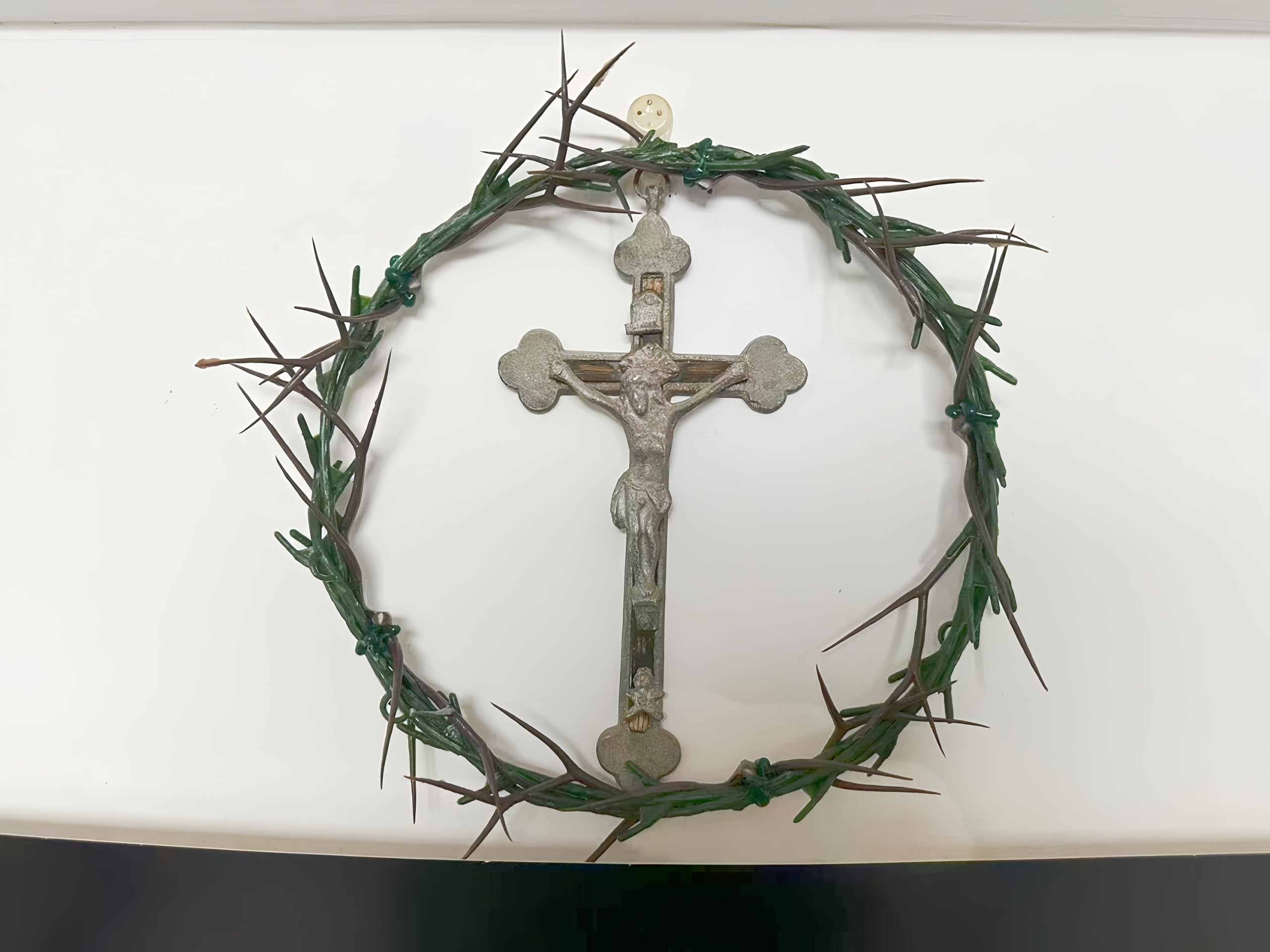 Close-up view of 8-inch diameter crown of thorns with artificial twigs on purple fabric.