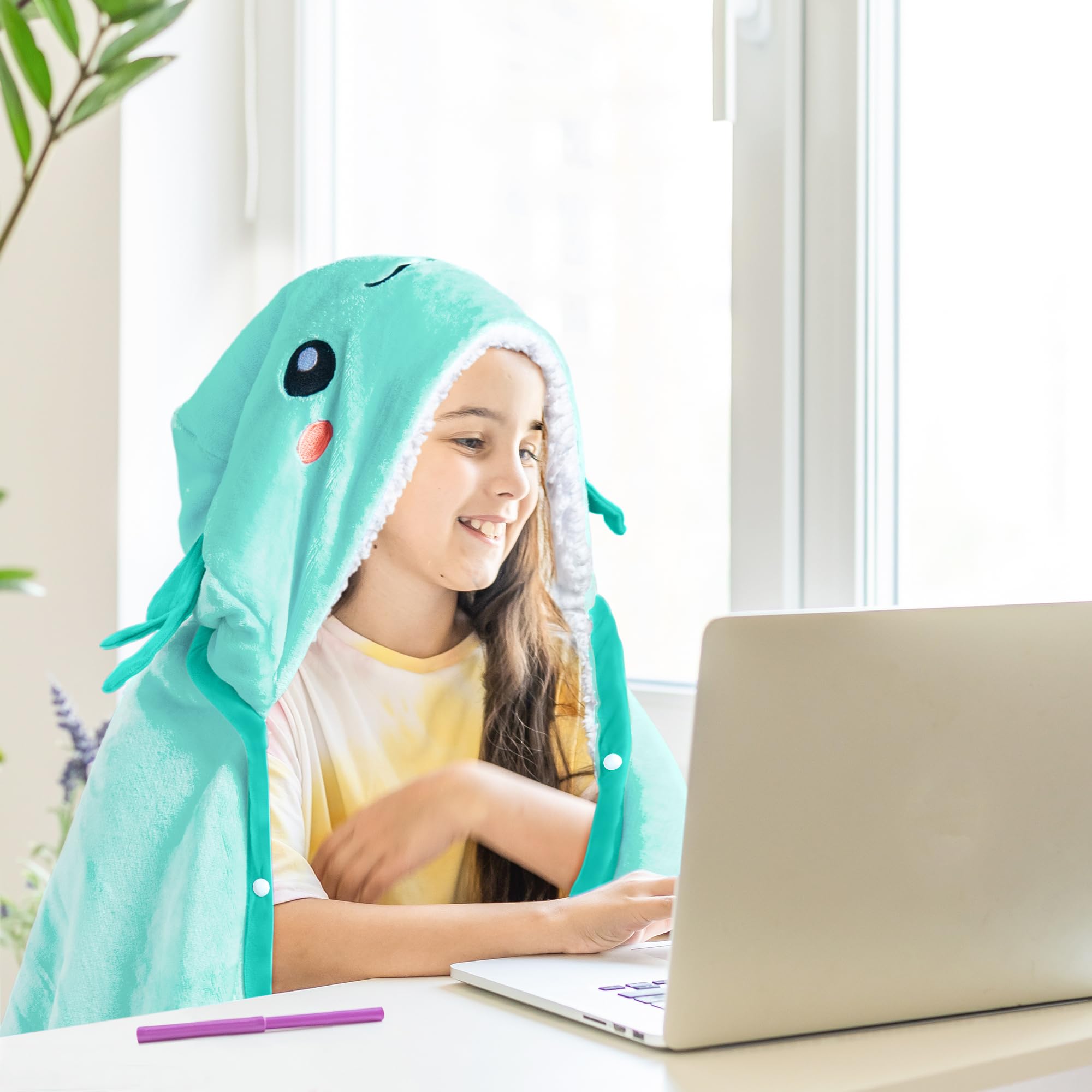 Happy Fuel Axolotl hooded blanket on a couch with coffee