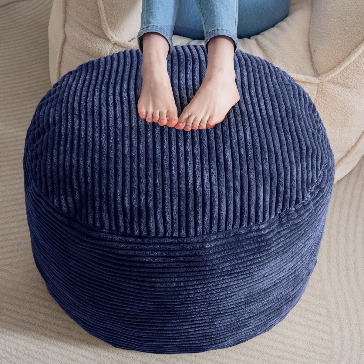 HIGOGOGO navy round pouf front view, inviting soft seating for a living room.