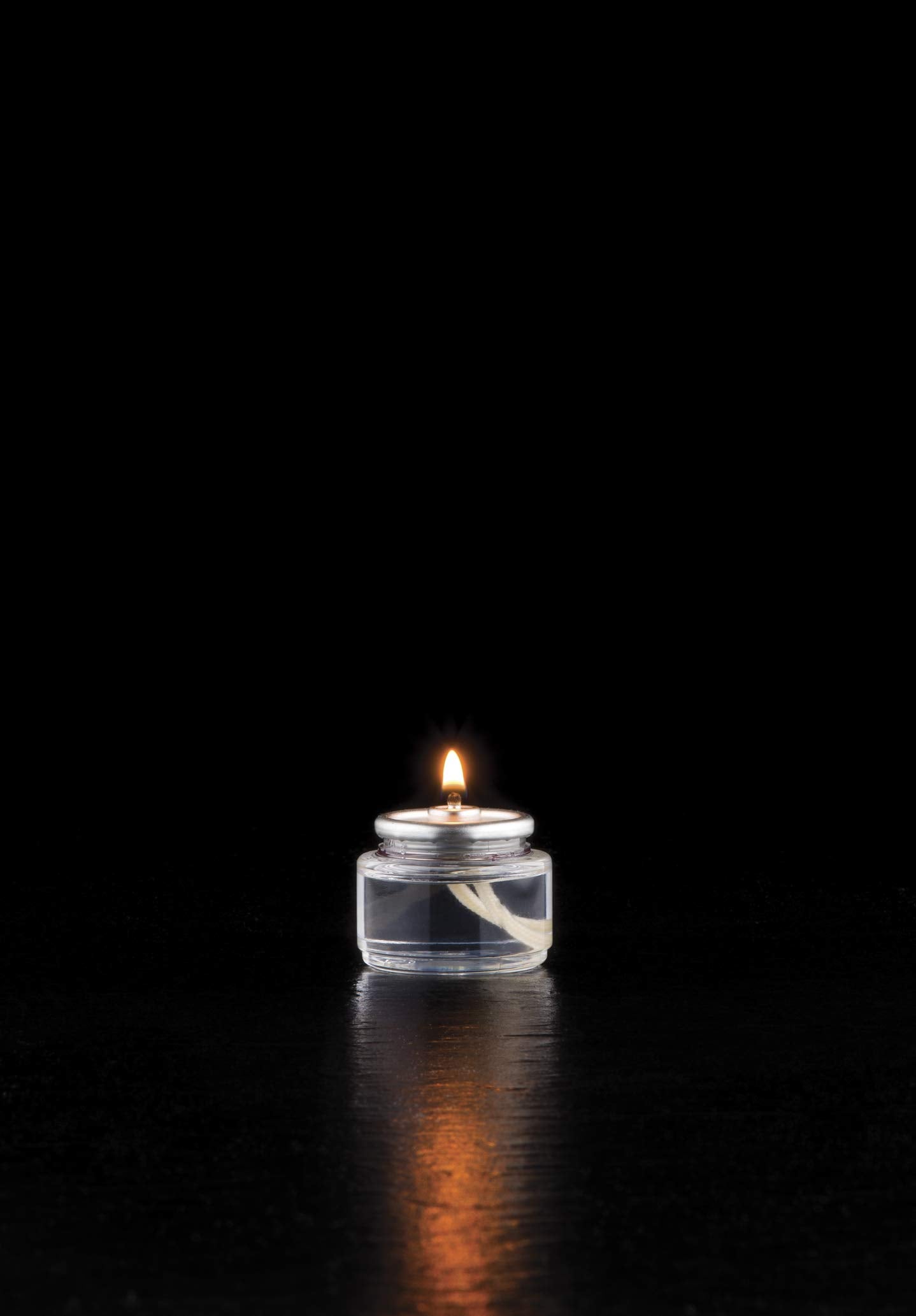 Hollowick candles in glass votive holders on tables.