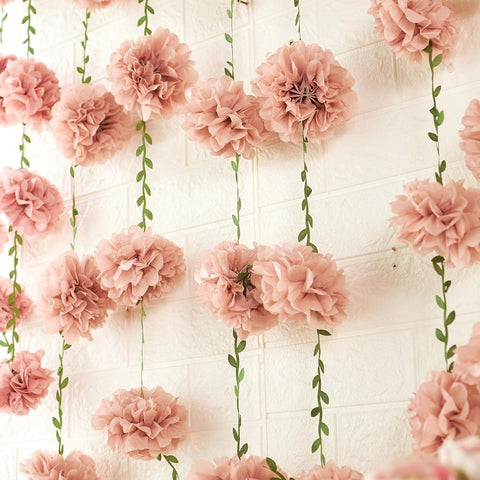 Homarkable pink tissue pom pom garland brightens party backdrops with soft, festive texture.
