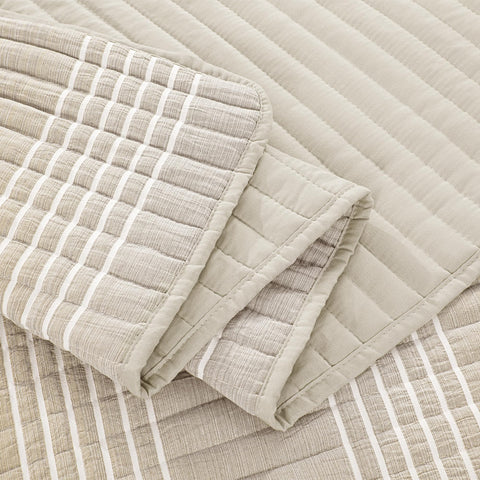 HOMBYS king bed shown with beige patchwork quilt centerpiece