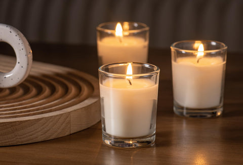 Housecret clear glass votives on table top enhancing ambience.