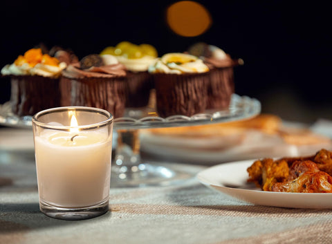 Votive candles arranged in lanterns during an outdoor evening party.
