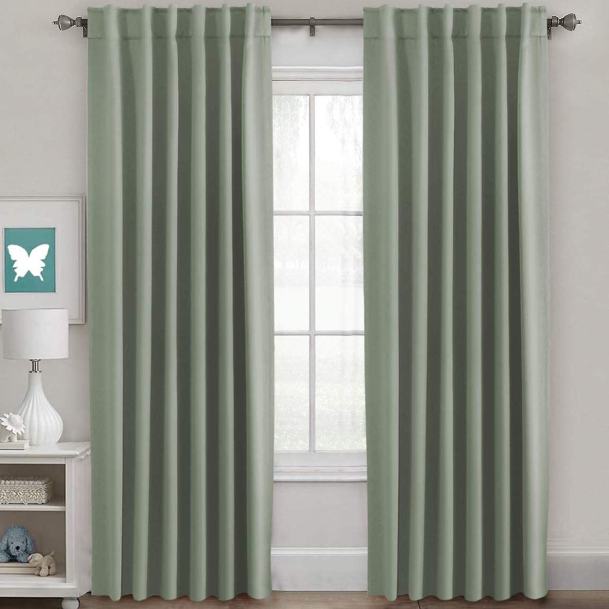 H.VERSAILTEX blackout curtains light sage pair of panels framing a window for enhanced privacy.