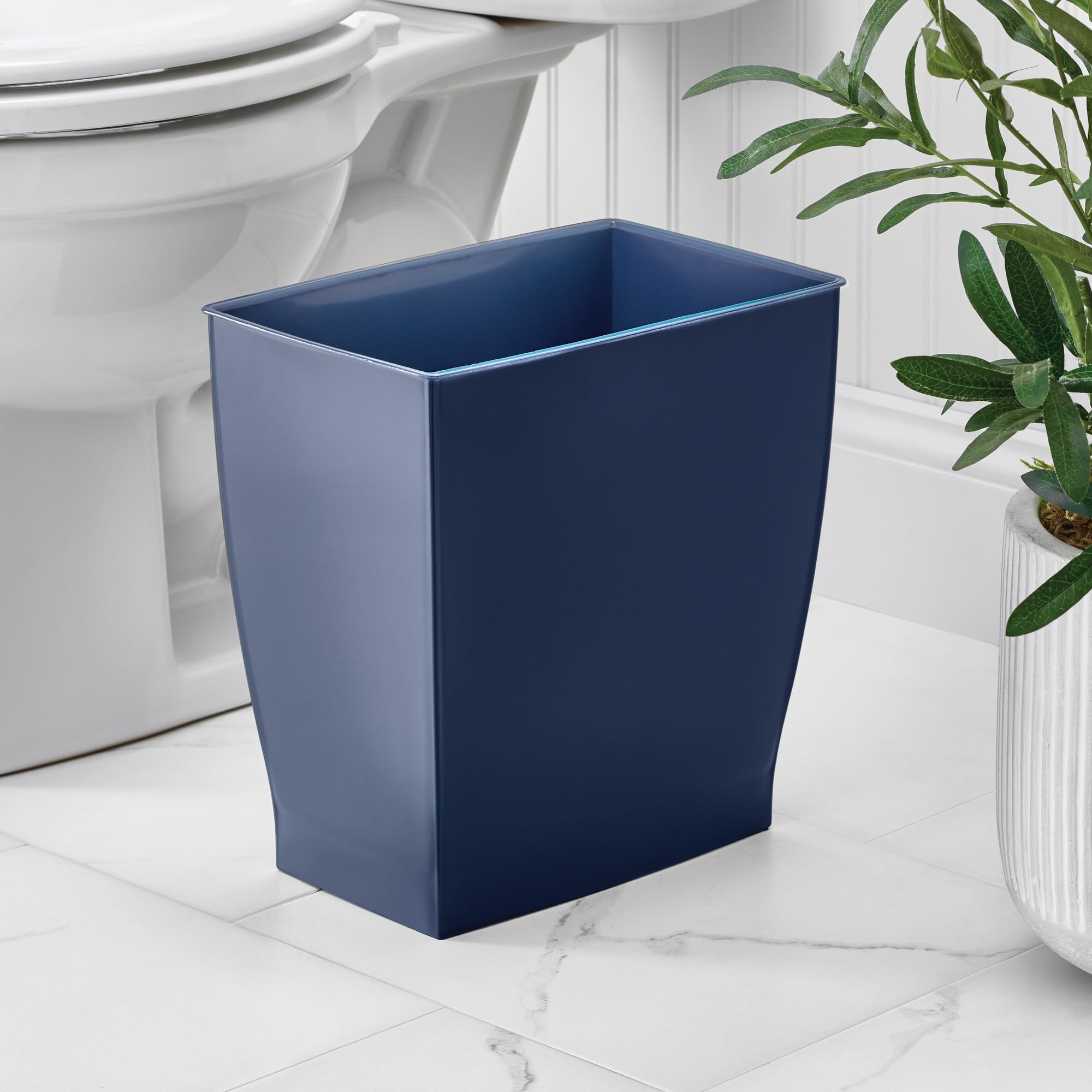 iDesign Mono trash can in navy blue in a bathroom vanity keeps disposal discreet.