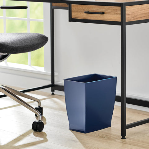 iDesign Mono trash can in navy blue used in a dorm room for compact waste management.