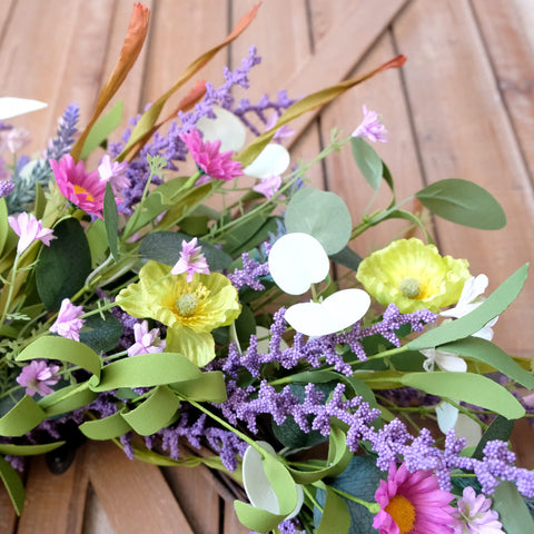 Idyllic rustic farmhouse wreath complements cozy entryways with natural grapevine backing.