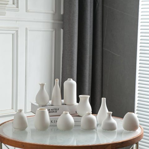 JOJUNO white bud vases in varied sizes create layered arrangements on tables.