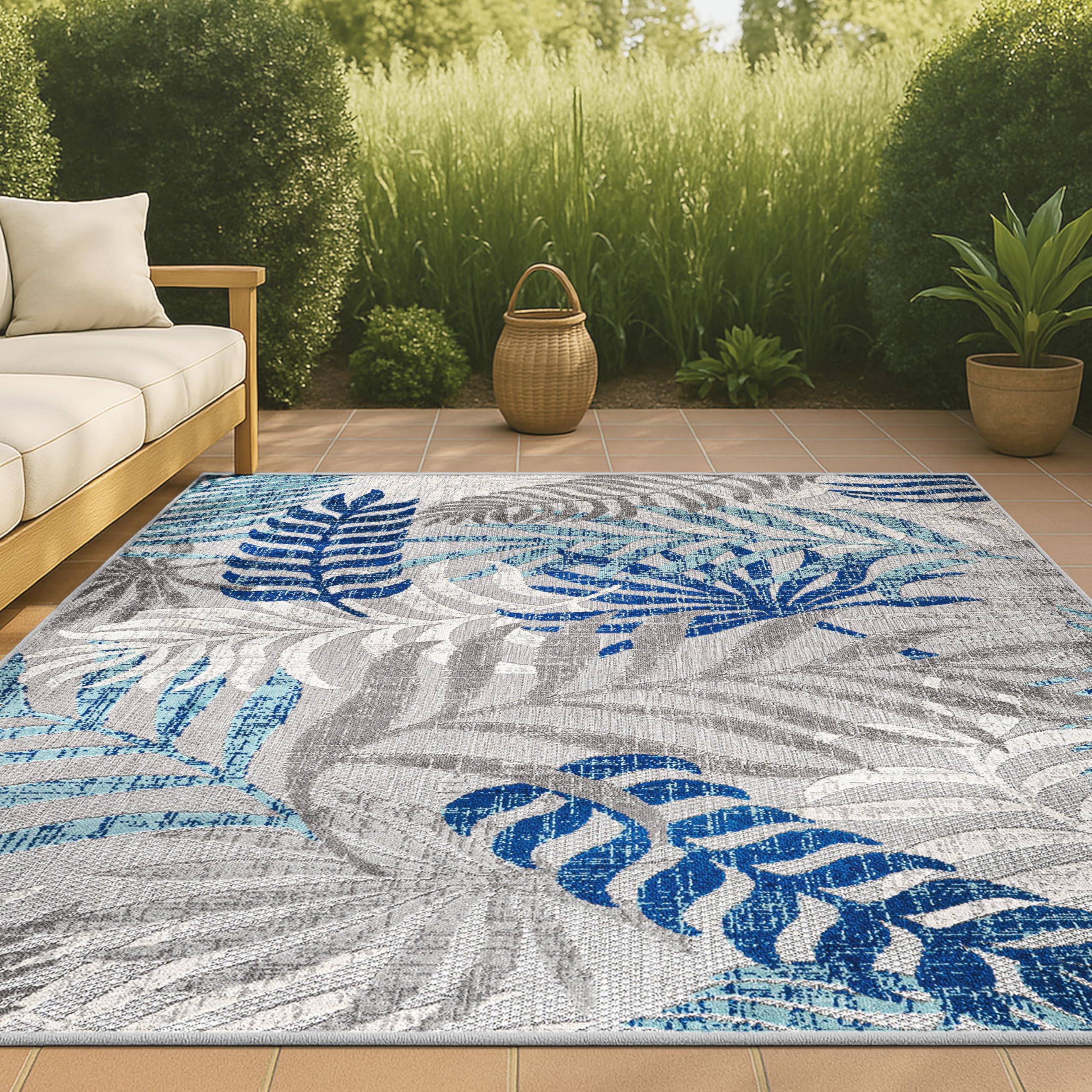 JONATHAN Y Tropics palm leaves rug on patio edge demonstrates easy-care, quick cleanup after spills.