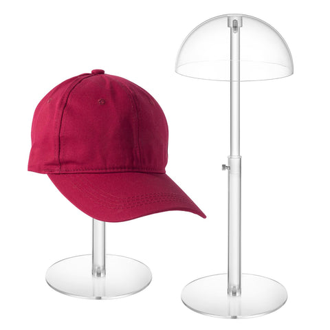 JUESHA clear acrylic hat display stand with a dome top showcasing hats neatly on the counter.