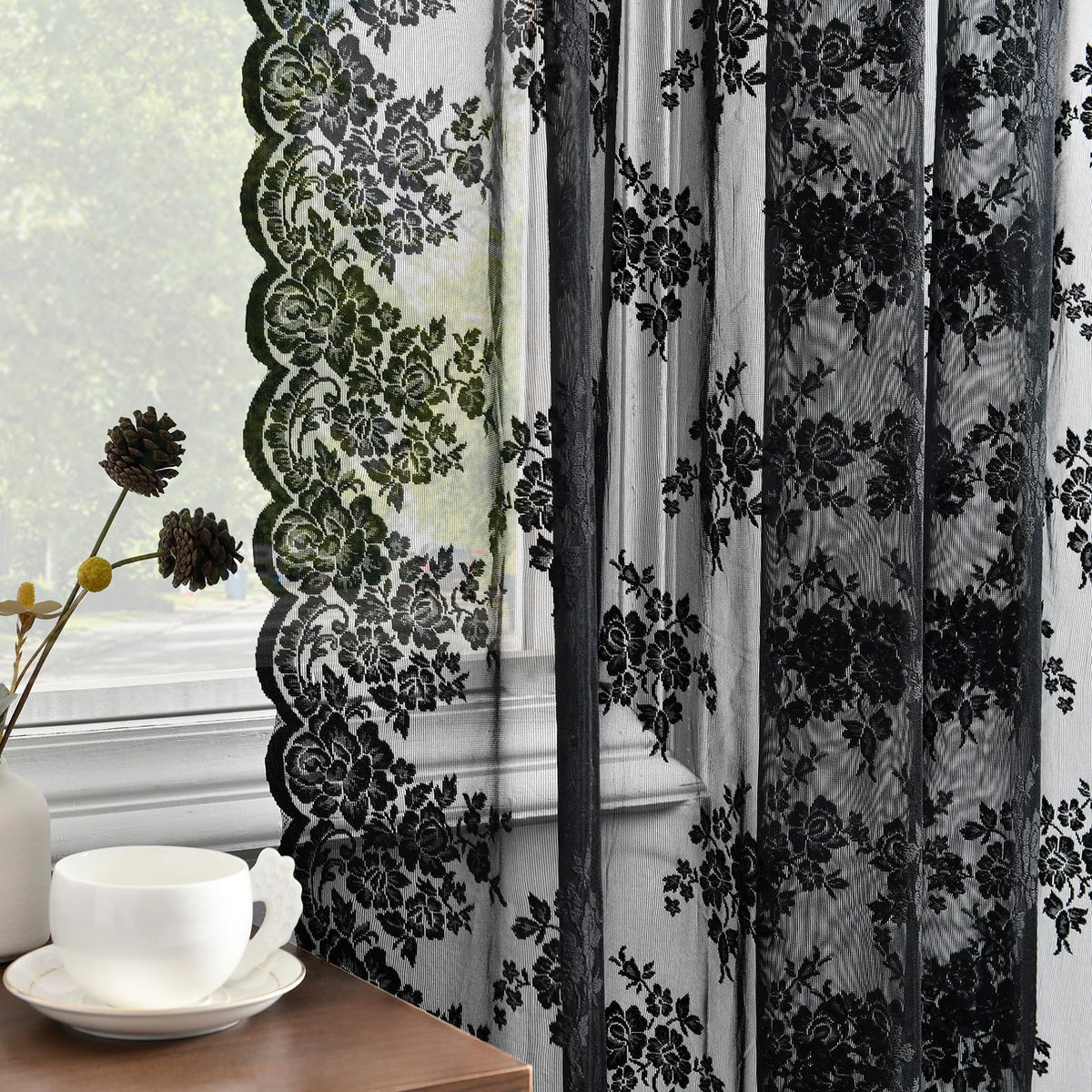 Kotile black lace curtains pair hanging on a rod, offering soft light and added privacy.