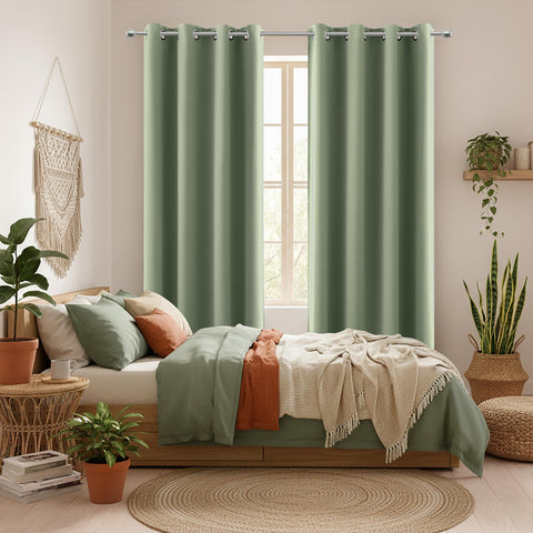 KOUFALL Sage Green blackout curtain panel in a cozy bedroom setting.